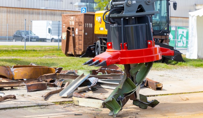 Ein Bagger gräbt auf einem Schrottplatz 